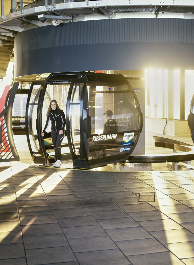 Moderne Gondelbahn der Kieserlbahn mit Person bei Sonnenaufgang an der Talstation | © Großarler Bergbahnen GmbH & Co KG