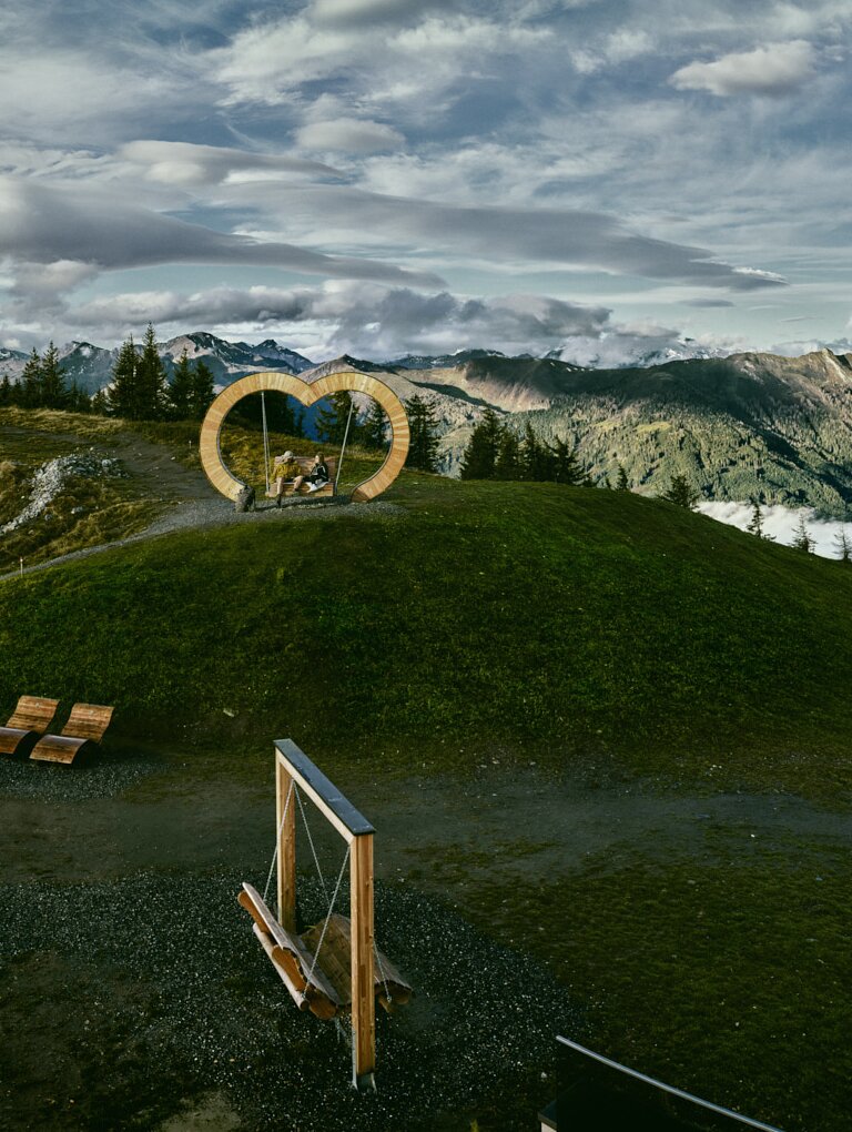 Wooden heart bench with alpine view and sea of clouds in the background | © Grossarler Bergbahnen GmbH & Co KG