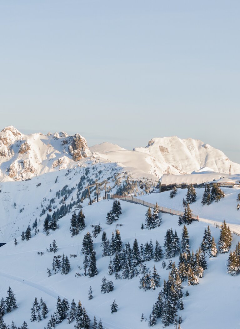 Snowy mountains with ski slope, trees and chairlift at sunrise | © Grossarler Bergbahnen GmbH & Co KG