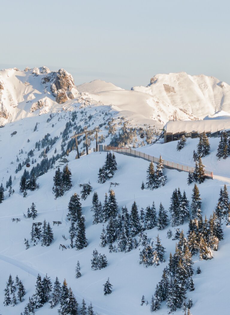 Snowy mountains with ski slope, trees and chairlift at sunrise | © Grossarler Bergbahnen GmbH & Co KG